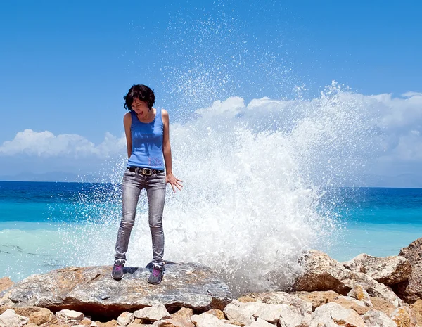 Girl under the spray of waves