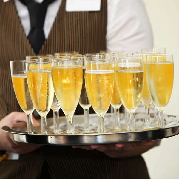 Waiter carrying a tray of champagne