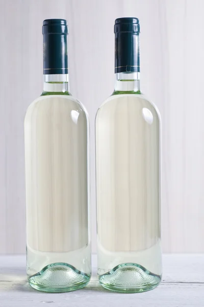 Two unlabelled bottles of white wine