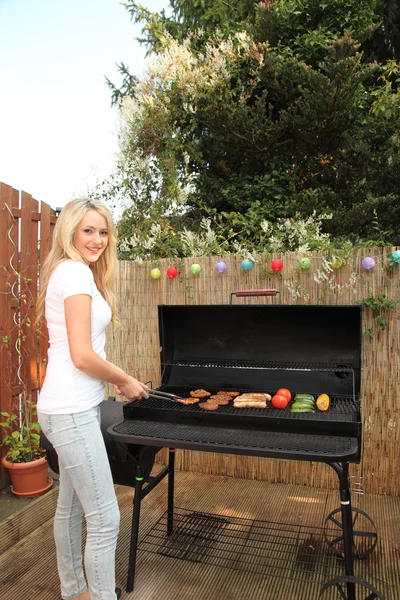 Young woman cooking on a barbecue outdoors