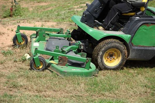 Ride on mower cutting grass