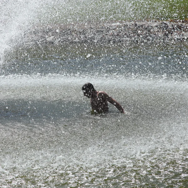 Man splashing under a jet of water