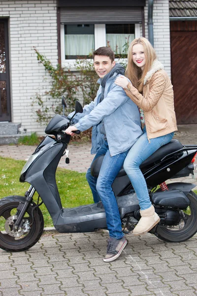Attractive young teenage couple on a motorcycle