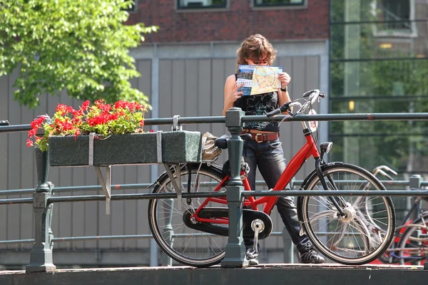 Tourist with map and bicycle. Amsterdam, Netherlands.