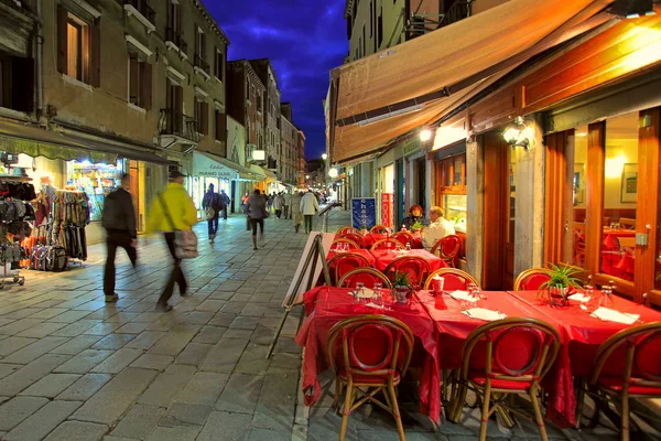 Outdoor restaurant on narrow street in Venice, Italy.