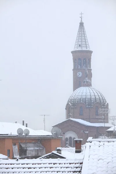 Church and roofs under the snow.