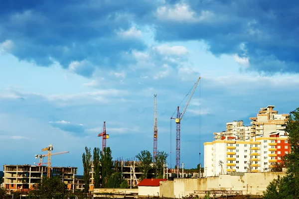 Residential building site with cranes and stormy clouds