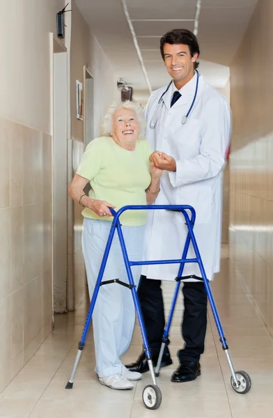 Doctor Assisting An Old Woman With Her Walker
