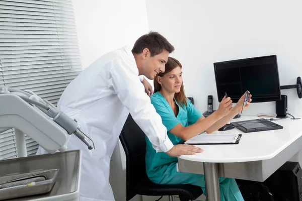 Dentist With Assistant Analyzing Report