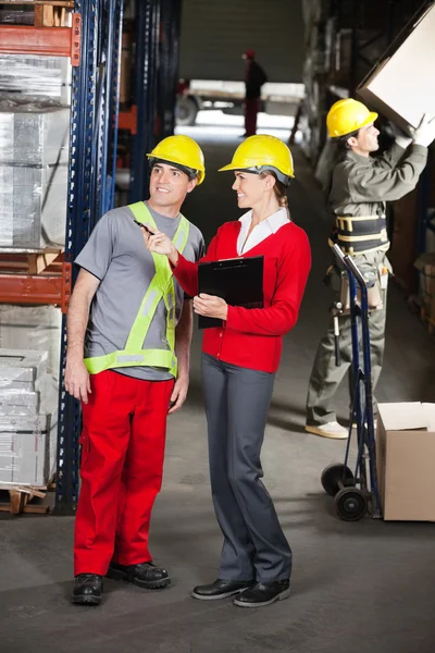 Supervisor Instructing Foreman At Warehouse