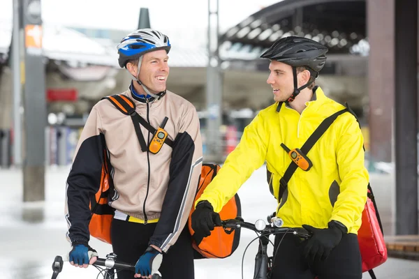 Courier Delivery Men With Bicycles Looking At Each Other