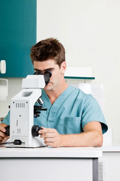 Male Researcher Using Microscope In Laboratory