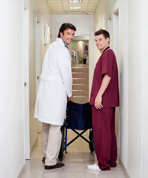 Doctor And Male Nurse In Hospital Corridor