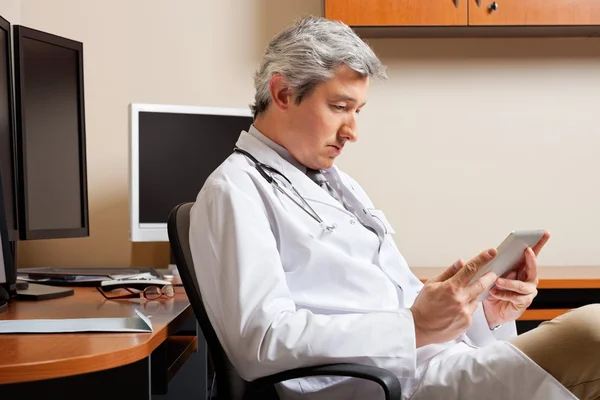 Serious Doctor Looking At Digital Tablet