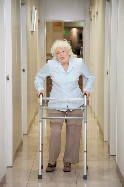 Elderly Woman With Walker In Hospital Corridor