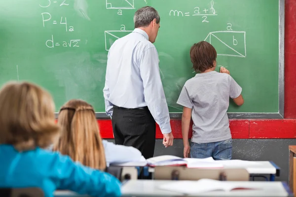 Schoolboy Solving Mathematics On Board In Classroom — Stock Photo #27431825