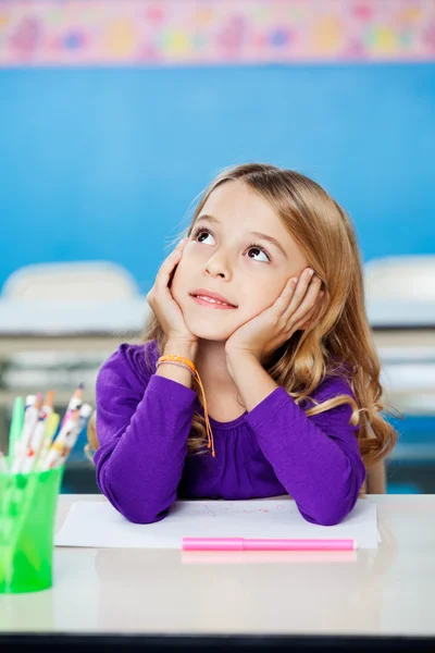 Girl Looking Up While Sitting With Head In Hands In Class