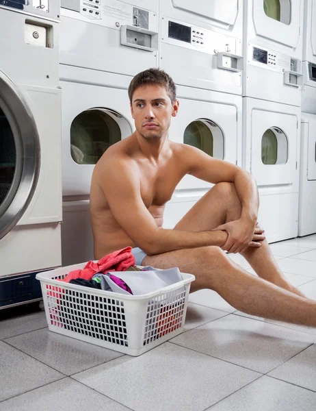 Bored Man With Laundry Basket Waiting To Wash Clothes