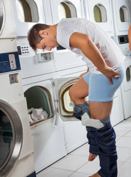Man Undressing His Clothes In Front Of Washing Machine
