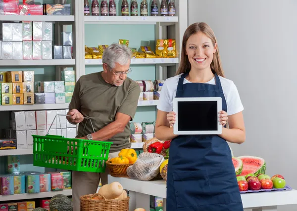 Saleswoman Showing Digital Tablet While Senior Man Shopping