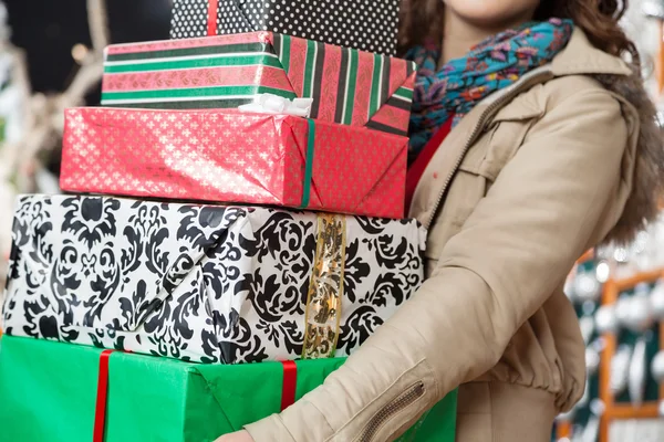 Woman Carrying Stacked Christmas Gifts