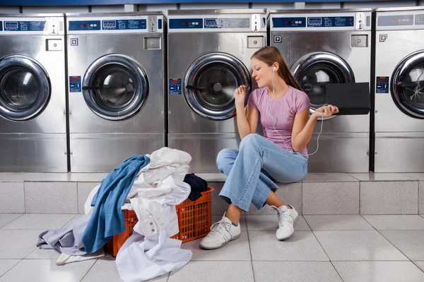 Woman Enjoying Music In Laundry