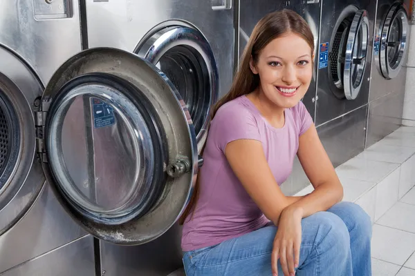Woman Sitting Against Washing Machines