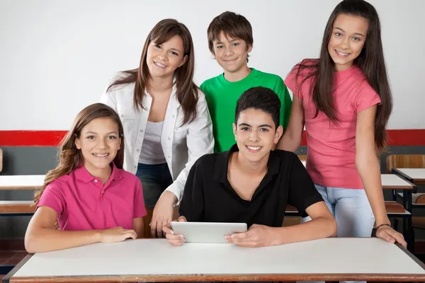 Portrait Of Teenage Students Using Tablet At Desk