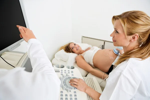 Obstetricians Scanning Pregnant Woman\'s Belly