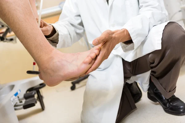 Doctor Examining Patient\'s Foot In Hospital