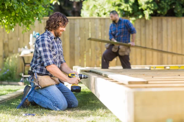 Manual Worker Drilling Wood At Construction Site