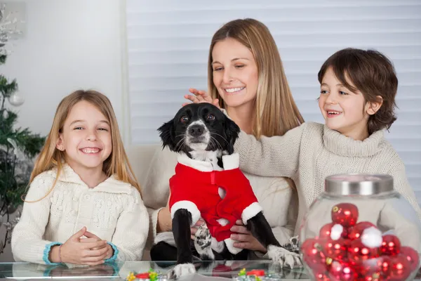 Family With Pet Dog At Home During Christmas