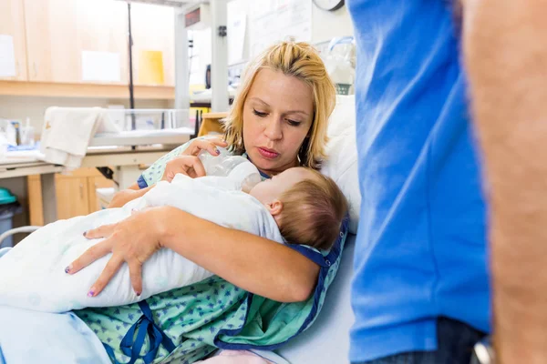 Woman Feeding Milk To Newborn Baby On Hospital Bed
