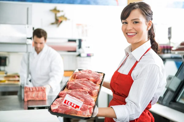 Happy Butcher Holding Meat Tray In Store