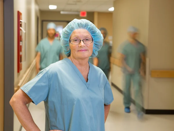 Doctor With Team Walking In Hospital Corridor