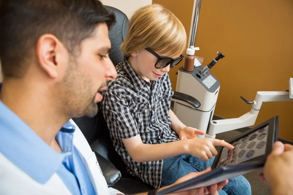 Boy Reading Test Chart While Optometrist