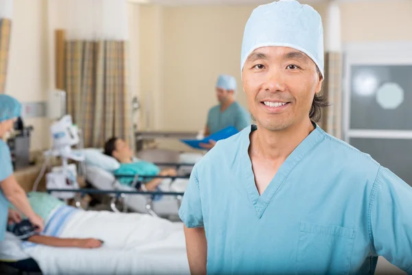 Smiling Male Nurse Standing In Hospital Ward