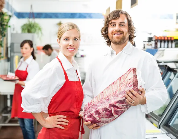 Confident Butchers With Meat Package