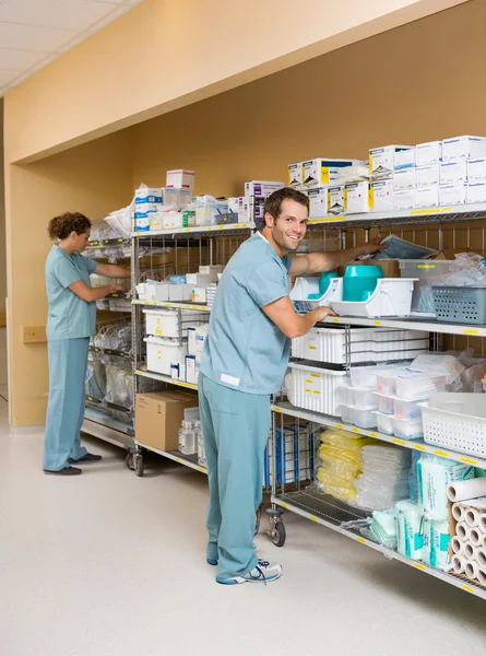 Nurses Arranging Stock On Shelves In Storage Room