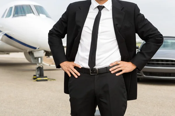 Entrepreneur Standing In Front Of Private Jet And Car