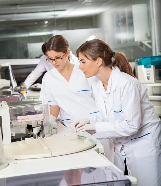 Researchers Operating Machine In Lab