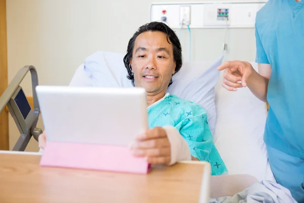 Nurse Pointing At Digital Tablet While Patient Using It