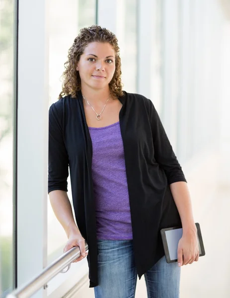 Confident Student Holding Digital Tablet At University Corridor