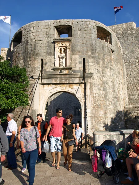 Tourists walk away from Main gate of the Old City of Dubrovnik