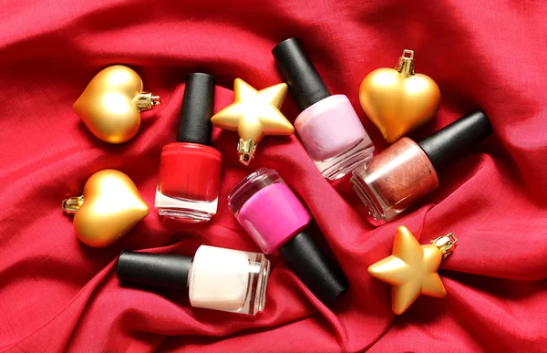 Makeup, Christmas or New Year party - nail polish on red silk