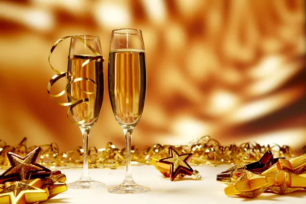 Glasses of champagne on yellow background