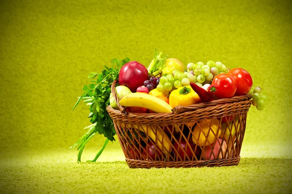 Basket full of fresh produce. green background