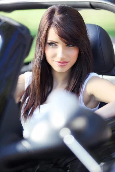 Sexy young woman driving black car.