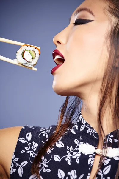 Asian woman eating sushi