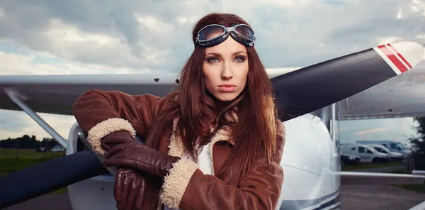 Woman pilot in front of airplane